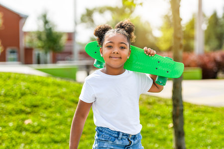 child skater or kid girl playing skateboard outsideの写真素材