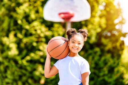 girl with basketball on court on summer seasonの写真素材