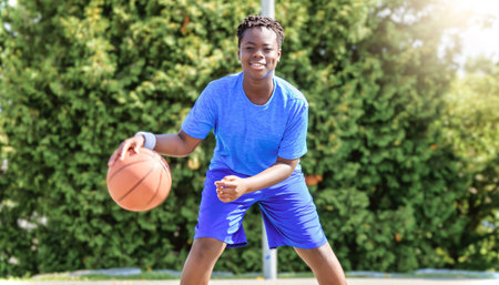 Portrait of american basketball player guy standing at basketball court with ball