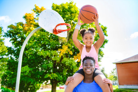 Portrait of brother and sister basketball player standing at basketball court with ballの写真素材