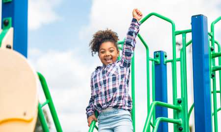 Cute American little kid girl having fun while playing on the playgroundの写真素材