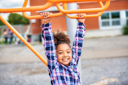 Cute American little kid girl having fun while playing on the playgroundの写真素材