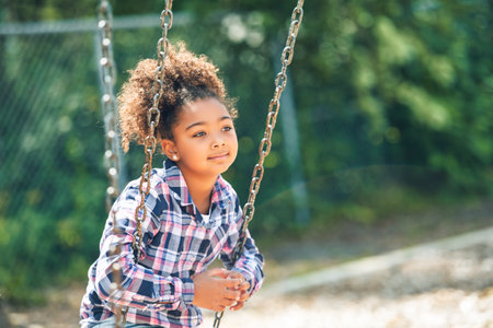Cute American little kid girl having fun while playing on the playgroundの写真素材