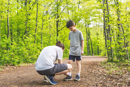 father and son attach shoes on a outdoor park having great funの写真素材