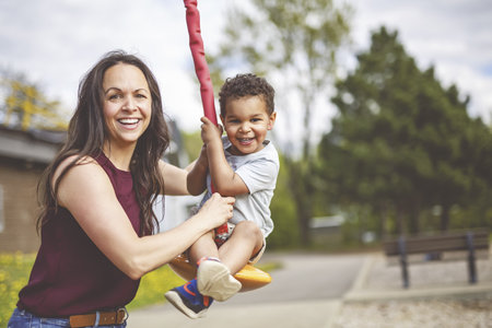 Playtime Moments. Mom With Her son Having Fun on the Playground Outside, Sharing Laughter and Joyful Bonding In Park Outdoorsの写真素材