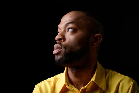 black African Man with yellow clothes on studio black background