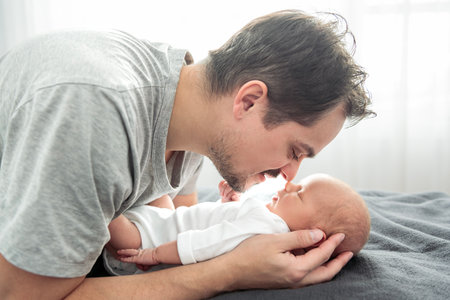 A Portrait of a father, with her nursing baby on bedroom