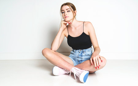 Portrait of young beautiful girl looking at camera over white background.