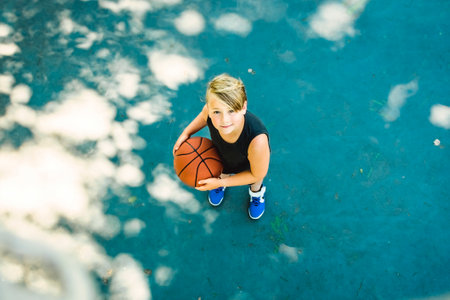 portrait of a boy kid playing with a basketball in parkの写真素材