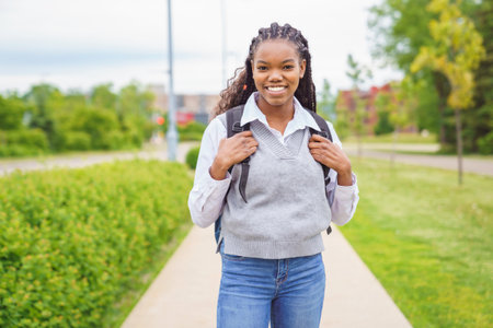 cute black female university student on campus with backpackの写真素材