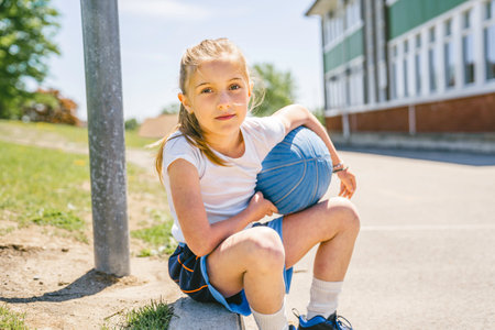 Girl holding a basketball at the park