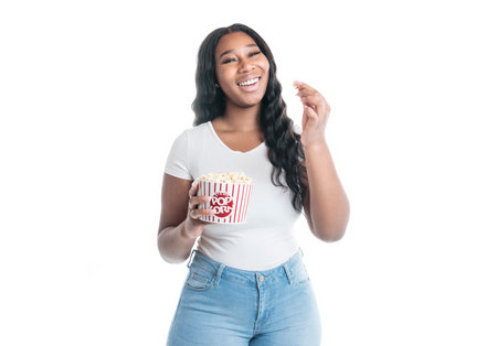Studio portrait of beautiful brunette young dark-skinned woman eat popcornの写真素材