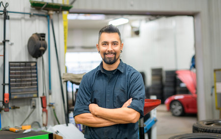 Handsome mechanic job in uniform working on carの写真素材