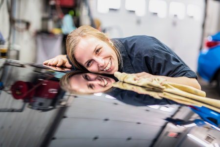 Woman at work cleaning automobile at car washの写真素材