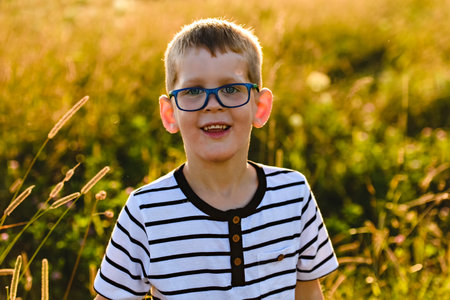 Portrait of a little boy walk in sunset on summer season