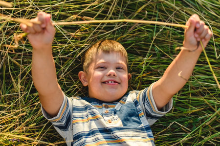 Portrait of a little boy with down syndrome in sunset on summer seasonの写真素材