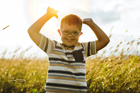 Portrait of a little boy with down syndrome in sunset on summer seasonの写真素材