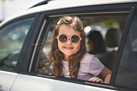 Young girl looking out of car window smiling