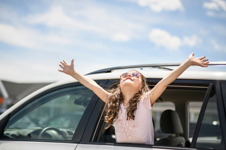 Young girl looking out of car window smiling