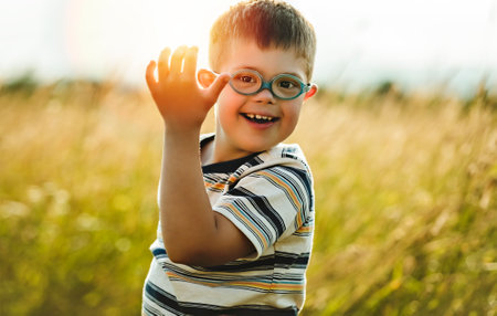 Portrait of a little boy with down syndrome in sunset on summer seasonの写真素材