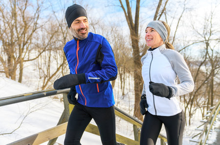 mature couple in the winter running on stairs together in natureの写真素材