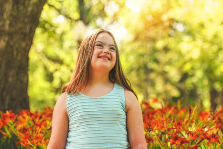 portrait of trisomy 21 child girl outside having fun on a parkの写真素材