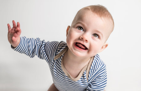 Cheerful baby boy toddler on white studio background