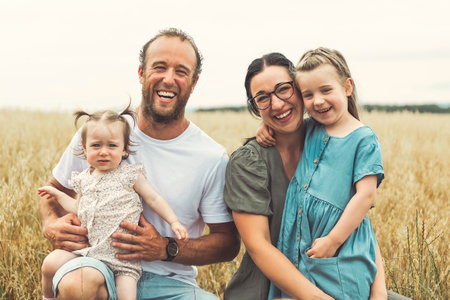 happy family with baby girl are playing in wheat field.の写真素材