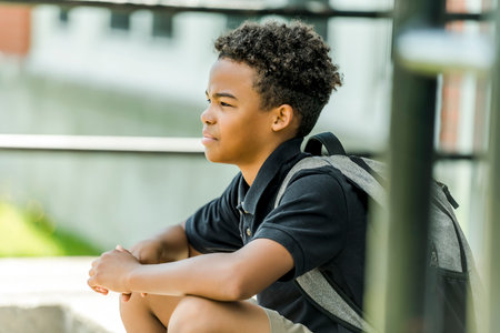 African american school boy with backpack outside