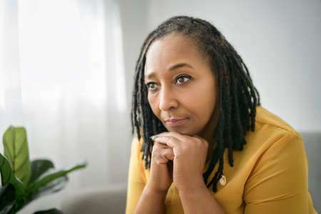 Portrait of an african woman sit on the sofa look worryの写真素材