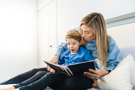Mom and child son are reading a book on bedroom