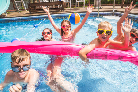 group of children having fun in Pool on the summer time