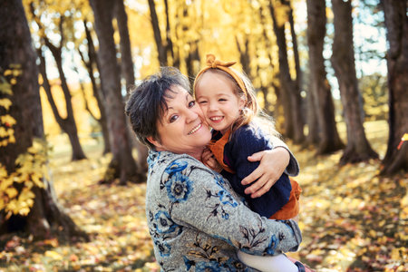 Grand Mother and little daughter in the Park and enjoying the beautiful autumn nature.の写真素材
