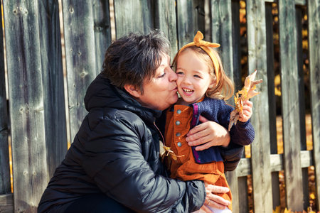 Grand Mother and little daughter in the Park and enjoying the beautiful autumn nature.