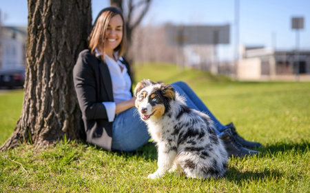 Handsome woman with her Australian Berger puppy city street outside
