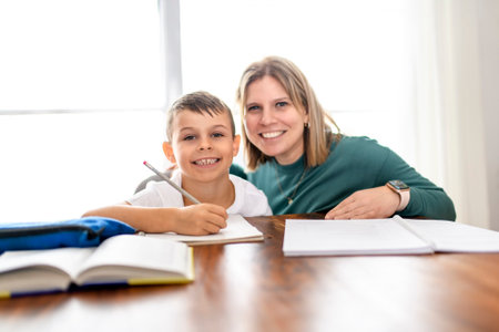 mother and son doing homework together at homeの写真素材