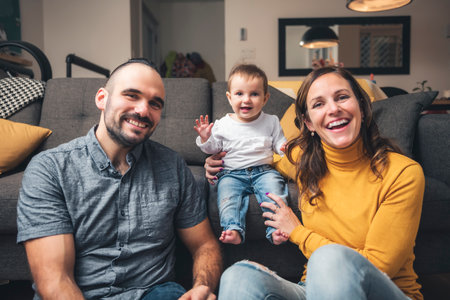 mother and father standing in their living room at home with baby girl