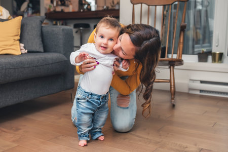 mother and baby girl having great time on the living roomの写真素材