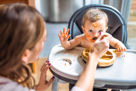 Little baby girl eating her dinner with her motherの写真素材