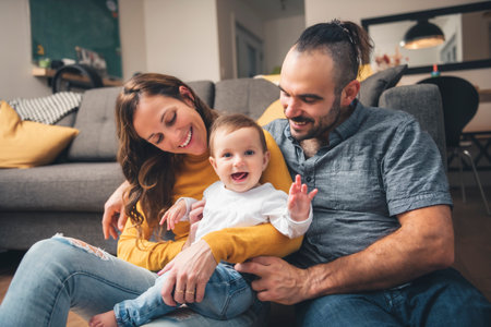 mother and father standing in their living room at home with baby girl