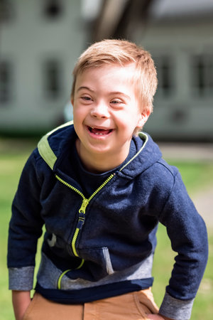 Portrait of a little boy with down syndrome while playing in a park