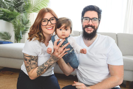 cute funny family wear white t-shirt playing with baby girl inside the living roomの写真素材