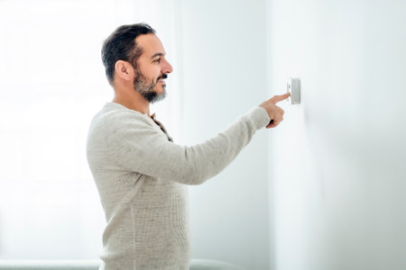 nice man set the thermostat at houseの写真素材