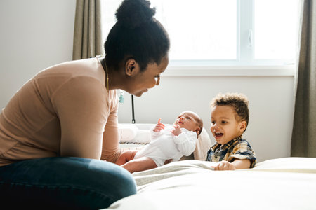 A Portrait of a beautiful black mother, with her nursing baby and child boy