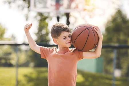 portrait of a boy kid playing with a basketball in parkの写真素材