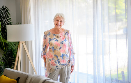 Active beautiful senior woman in the living room.の写真素材