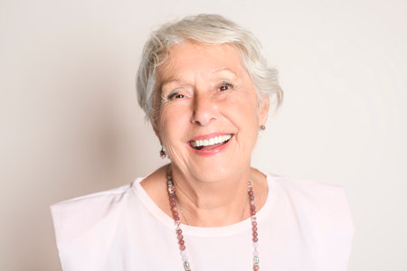 smiling retired senior woman looking at camera isolated on white background