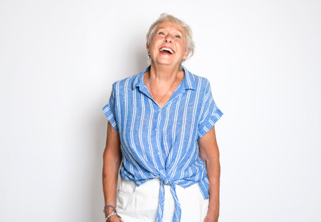 smiling retired senior woman looking at camera isolated on white backgroundの写真素材