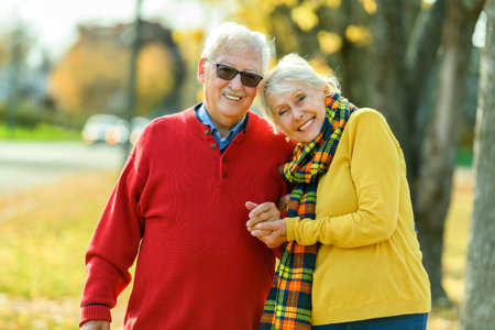 Beautiful Elderly couple embracing in autumn parkの写真素材
