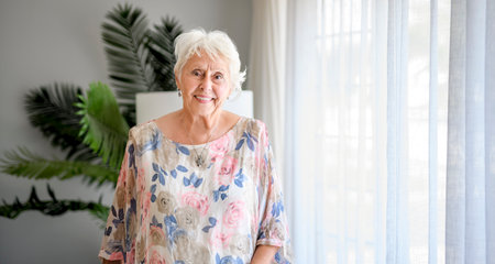 Active beautiful senior woman in the living room.の写真素材